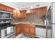 Well-maintained kitchen featuring wooden cabinets, granite countertops, stainless steel appliances, and mosaic backsplash at 7110 E Continental Dr # 2008, Scottsdale, AZ 85257