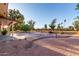 View of backyard with manicured landscaping, mature trees, and a unique water feature at 7220 E Edgewood Ave, Mesa, AZ 85208