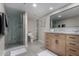 Bathroom featuring tiled floors, modern vanity, walk-in shower with glass enclosure, and linen shelves at 7220 E Edgewood Ave, Mesa, AZ 85208