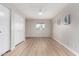 Bright bedroom with light wood-look flooring, fresh paint, a ceiling fan, and closet with bi-fold doors at 7220 E Edgewood Ave, Mesa, AZ 85208