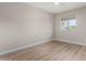 A minimalistic bedroom with a ceiling fan, a window for natural light, and wood flooring at 7220 E Edgewood Ave, Mesa, AZ 85208