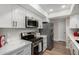 Modern kitchen featuring white cabinets, stainless steel appliances, and quartz countertops at 7220 E Edgewood Ave, Mesa, AZ 85208