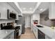 Modern kitchen featuring white cabinets, stainless steel appliances, and quartz countertops at 7220 E Edgewood Ave, Mesa, AZ 85208
