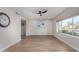 Spacious living room features wood-look floors, a ceiling fan, and a large window with neighborhood views at 7220 E Edgewood Ave, Mesa, AZ 85208