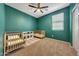 Bedroom featuring a ceiling fan, a window with blinds, and two cribs at 7236 W Townley Ave, Peoria, AZ 85345