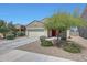 Inviting single-story home showcasing desert landscaping, a two-car garage, and a welcoming red front door at 7236 W Townley Ave, Peoria, AZ 85345