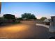 Large backyard with brick pavers, outdoor fireplace, and mature trees provides ample room for entertaining at 7973 S Peppertree Ct, Gilbert, AZ 85298