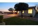 Inviting backyard features a brick patio, outdoor fireplace, built-in grill, and lush landscaping at 7973 S Peppertree Ct, Gilbert, AZ 85298