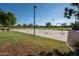 Community basketball court surrounded by green grass and trees for outdoor recreation at 7973 S Peppertree Ct, Gilbert, AZ 85298