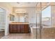 Bathroom featuring double sinks, tiled floors, soaking tub, and walk-in glass shower at 7973 S Peppertree Ct, Gilbert, AZ 85298