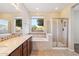 A bright bathroom offers double sinks, tile floors, soaking tub, and separate glass shower at 7973 S Peppertree Ct, Gilbert, AZ 85298