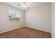 Well-lit bedroom showcasing carpet, ceiling fan, and a window with views at 7973 S Peppertree Ct, Gilbert, AZ 85298
