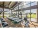Bright gym with treadmills, workout equipment, and floor-to-ceiling windows overlooking a lake at 7973 S Peppertree Ct, Gilbert, AZ 85298