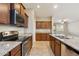 Well-equipped kitchen with stainless steel appliances, granite countertops, and a view of the living space at 7973 S Peppertree Ct, Gilbert, AZ 85298