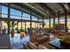 Spacious lounge area with leather seating, fireplace, and lake views for relaxation and socializing at 7973 S Peppertree Ct, Gilbert, AZ 85298