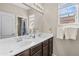 Clean bathroom with double sinks, a large mirror, and natural light from a window at 9132 S Parkside Dr, Tempe, AZ 85284