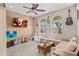 Cozy bedroom with a ceiling fan, two windows, tan walls, carpeted floors, and a large sectional couch at 9132 S Parkside Dr, Tempe, AZ 85284