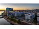 Stunning aerial view of modern apartment complex featuring palm trees and a tranquil river view at sunset at 945 E Playa Del Norte Dr # 1022, Tempe, AZ 85288