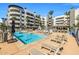 Relaxing pool area surrounded by lounge chairs, outdoor fireplace, and lush palms at 945 E Playa Del Norte Dr # 1022, Tempe, AZ 85288