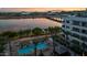 Aerial view of a community pool, palm trees, and lakeside apartment buildings at 945 E Playa Del Norte Dr # 1022, Tempe, AZ 85288