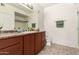 A bathroom with double sinks, granite counters, and wood cabinets at 9820 N Central Ave # 307, Phoenix, AZ 85020