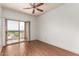 Bright bedroom featuring hardwood floors, fan and large sliding doors leading to a balcony at 9820 N Central Ave # 324, Phoenix, AZ 85020
