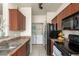Well-lit kitchen featuring updated cabinetry, countertops, black appliances with laundry area at 9820 N Central Ave # 324, Phoenix, AZ 85020
