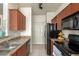 Well-lit kitchen featuring updated cabinetry, countertops, black appliances and tiled floors at 9820 N Central Ave # 324, Phoenix, AZ 85020