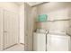 Bright laundry room with washer and dryer units with a storage shelf and entry door at 9820 N Central Ave # 324, Phoenix, AZ 85020