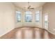 Cozy living room with three large windows, ceiling fan, wood flooring, and access to a balcony at 9820 N Central Ave # 324, Phoenix, AZ 85020