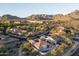 Expansive aerial view showcasing the community, lush landscaping, and stunning mountain backdrop at 9865 E Piedra Dr, Scottsdale, AZ 85255