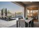 Outdoor patio area with dining table, seating, and view of a sparkling swimming pool at 9865 E Piedra Dr, Scottsdale, AZ 85255