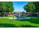 Beautiful community fountain on a green lawn with mountain views and mature landscaping at 9865 E Piedra Dr, Scottsdale, AZ 85255