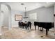 A dining room featuring a piano, modern light fixture, neutral paint, and tile floors at 9865 E Piedra Dr, Scottsdale, AZ 85255
