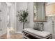 Inviting entryway with neutral colors, tile floor, decorative tree, a mirror, and bench with pillow at 9865 E Piedra Dr, Scottsdale, AZ 85255