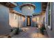 Unique home entrance with a turret feature, arched doorway, and desert landscaping, offering curb appeal at 9865 E Piedra Dr, Scottsdale, AZ 85255