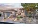 Inviting desert-landscaped front yard with desert plants and rock stream in front of a stucco home with tile roof at 9865 E Piedra Dr, Scottsdale, AZ 85255