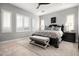 Serene main bedroom showcasing a dark wood bed frame, light wood floors, and many windows at 9865 E Piedra Dr, Scottsdale, AZ 85255