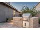Modern outdoor kitchen featuring stainless steel grill and stylish stone surround at 9865 E Piedra Dr, Scottsdale, AZ 85255