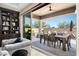 Inviting outdoor patio with dining table and chairs, sliding glass doors, and a serene view of the backyard at 9865 E Piedra Dr, Scottsdale, AZ 85255