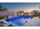 Beautiful pool with integrated waterfall feature and travertine decking, perfect for evening relaxation at 9865 E Piedra Dr, Scottsdale, AZ 85255