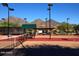 Well-maintained community tennis court featuring mountain views and shaded seating area at 9865 E Piedra Dr, Scottsdale, AZ 85255