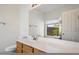 Bathroom vanity with a large mirror, neutral countertop and window view at 10152 E Knowles Ave, Mesa, AZ 85209