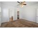 A bright carpeted bedroom with a ceiling fan, and views to a bathroom and walk-in closet at 10152 E Knowles Ave, Mesa, AZ 85209
