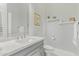 Bright half bath features a gray vanity with storage space and shelves with decor at 104 E Louis Way, Tempe, AZ 85284