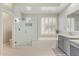 Bright bathroom features a glass shower, tub, and a large window with shutters at 104 E Louis Way, Tempe, AZ 85284