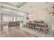 A spacious dining room and living room with hardwood floors and modern furnishings, perfect for entertaining at 104 E Louis Way, Tempe, AZ 85284