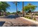 Elegant gated community entrance featuring brick-paved roads, lush landscaping, and stately palm trees at 104 E Louis Way, Tempe, AZ 85284