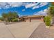 Charming single-story home featuring desert landscaping, a tile roof, and an inviting front facade with a three car garage at 104 E Louis Way, Tempe, AZ 85284