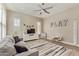 Cozy living room with plush sofa, ceiling fan, and large windows offering ample natural light at 104 E Louis Way, Tempe, AZ 85284